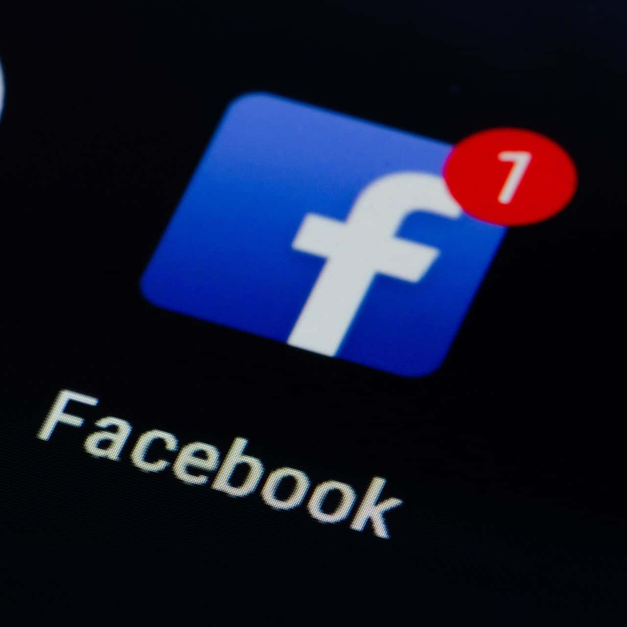 在深色屏幕上顯示一個通知的Facebook應用程式圖標。