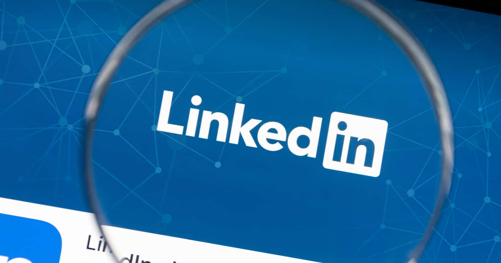 放大鏡在藍色網絡背景上突出顯示LinkedIn標誌。
