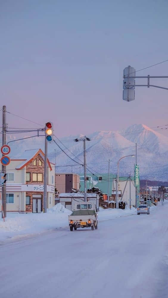 雪街、皮卡車和山脈在黃昏