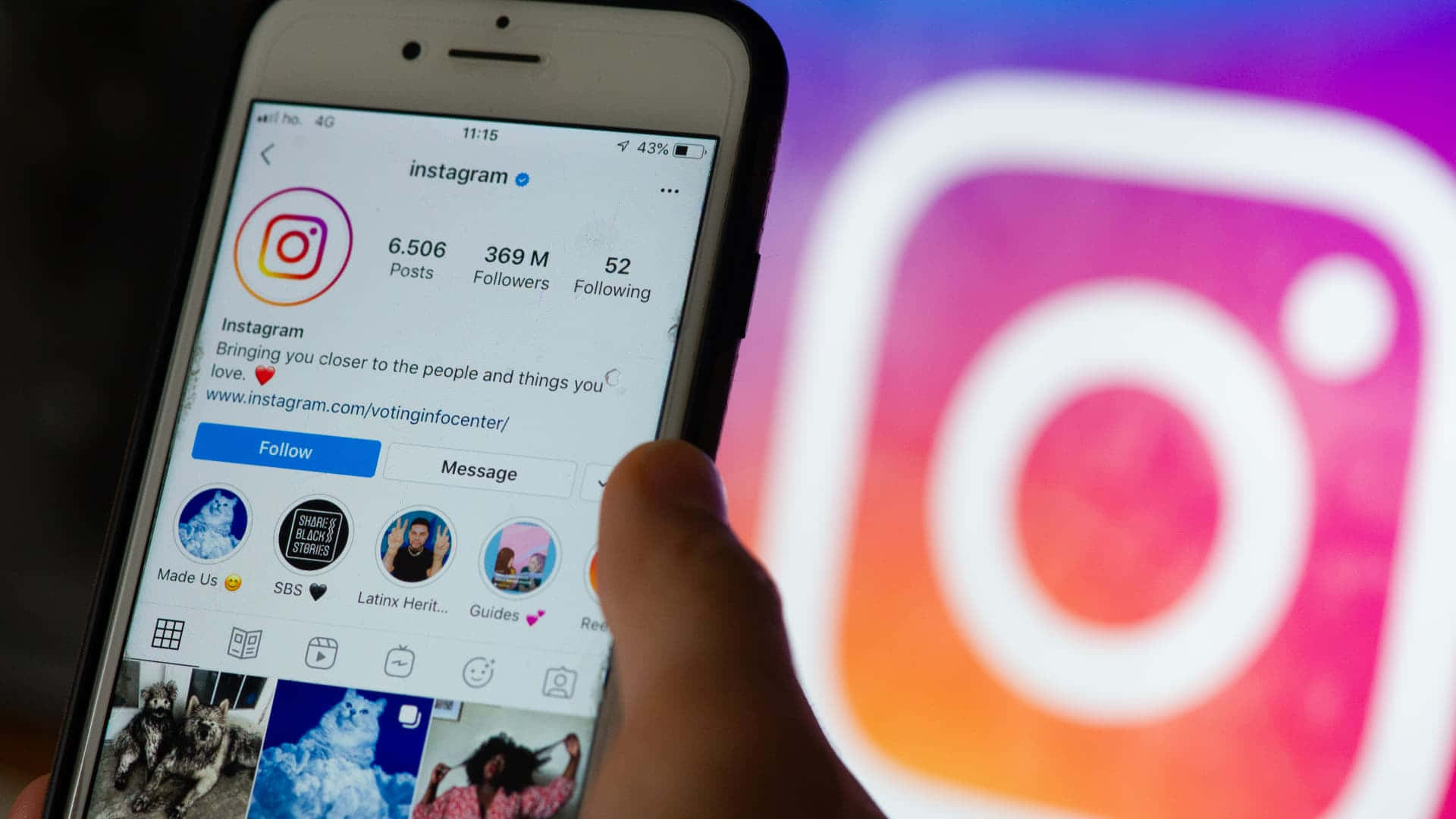 手拿著電話顯示Instagram個人資料，背後有模糊的應用程式標誌。