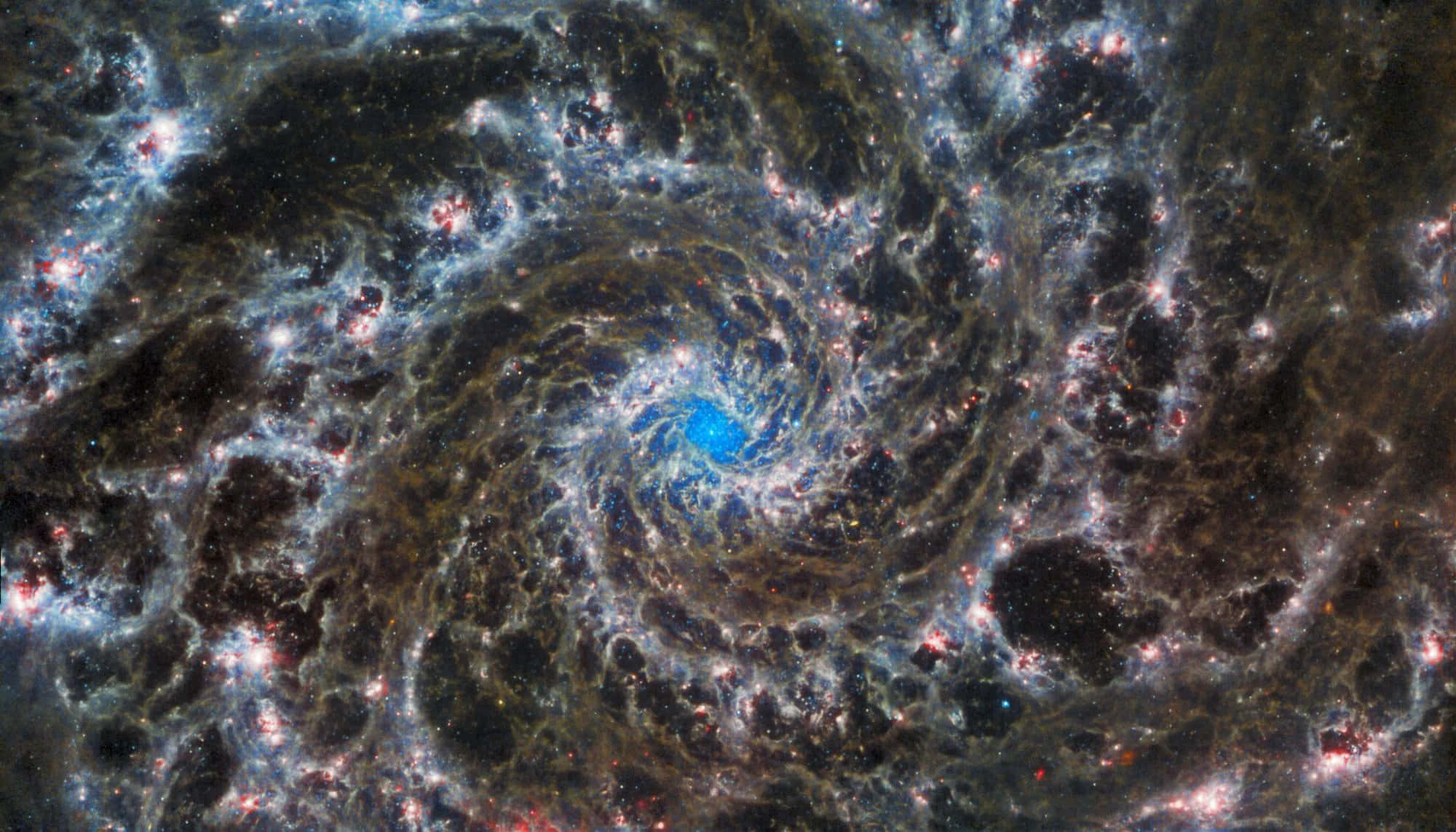 透過NASA望遠鏡探索宇宙中的星系 壁紙 — 一個令人嘆為觀止的螺旋星系，伴隨著宇宙塵埃和發光的恆星，從明亮的藍色核心輻射而出。