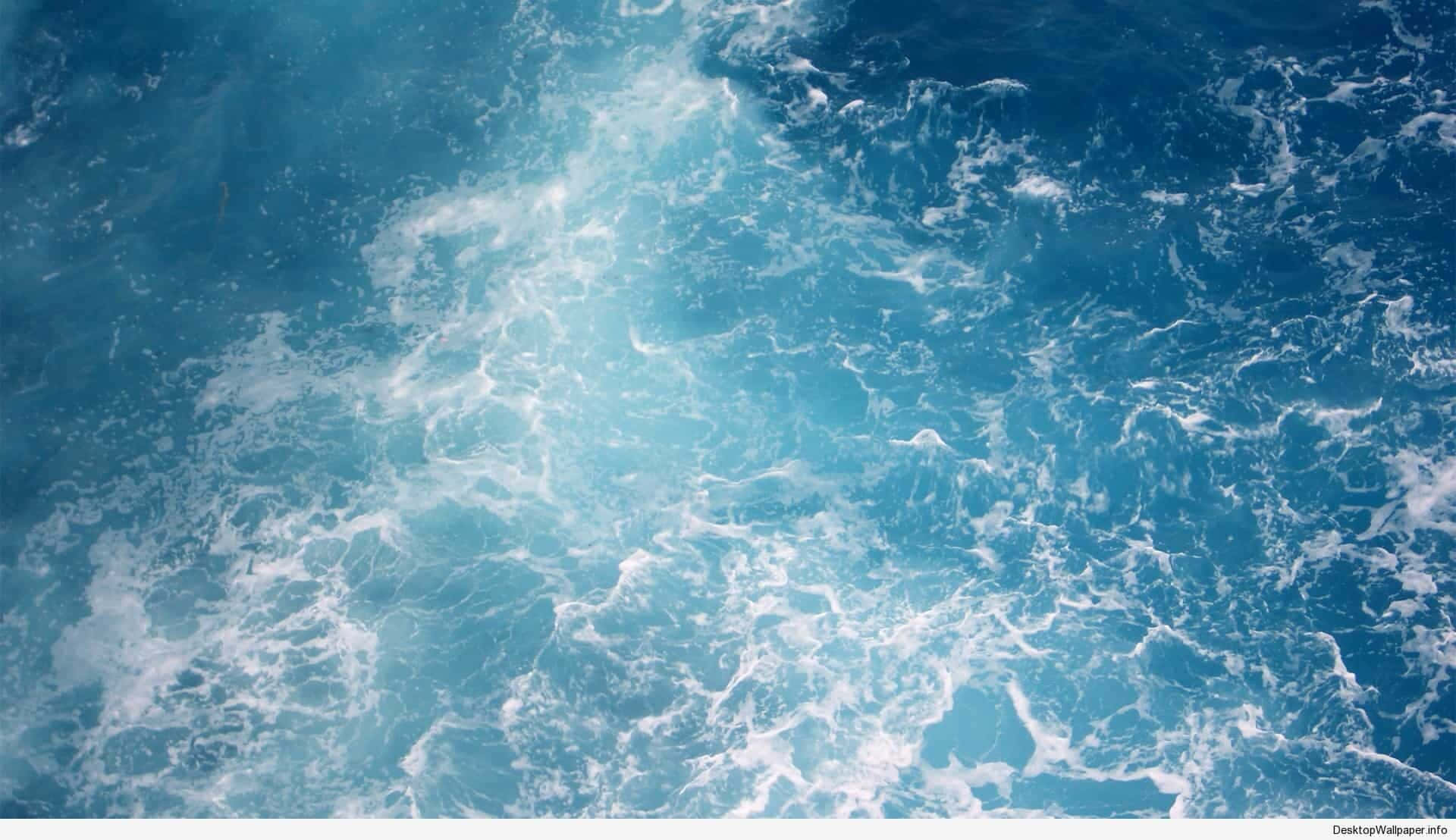 從空中視角看，深藍色海水中旋轉的泡沫海浪。
