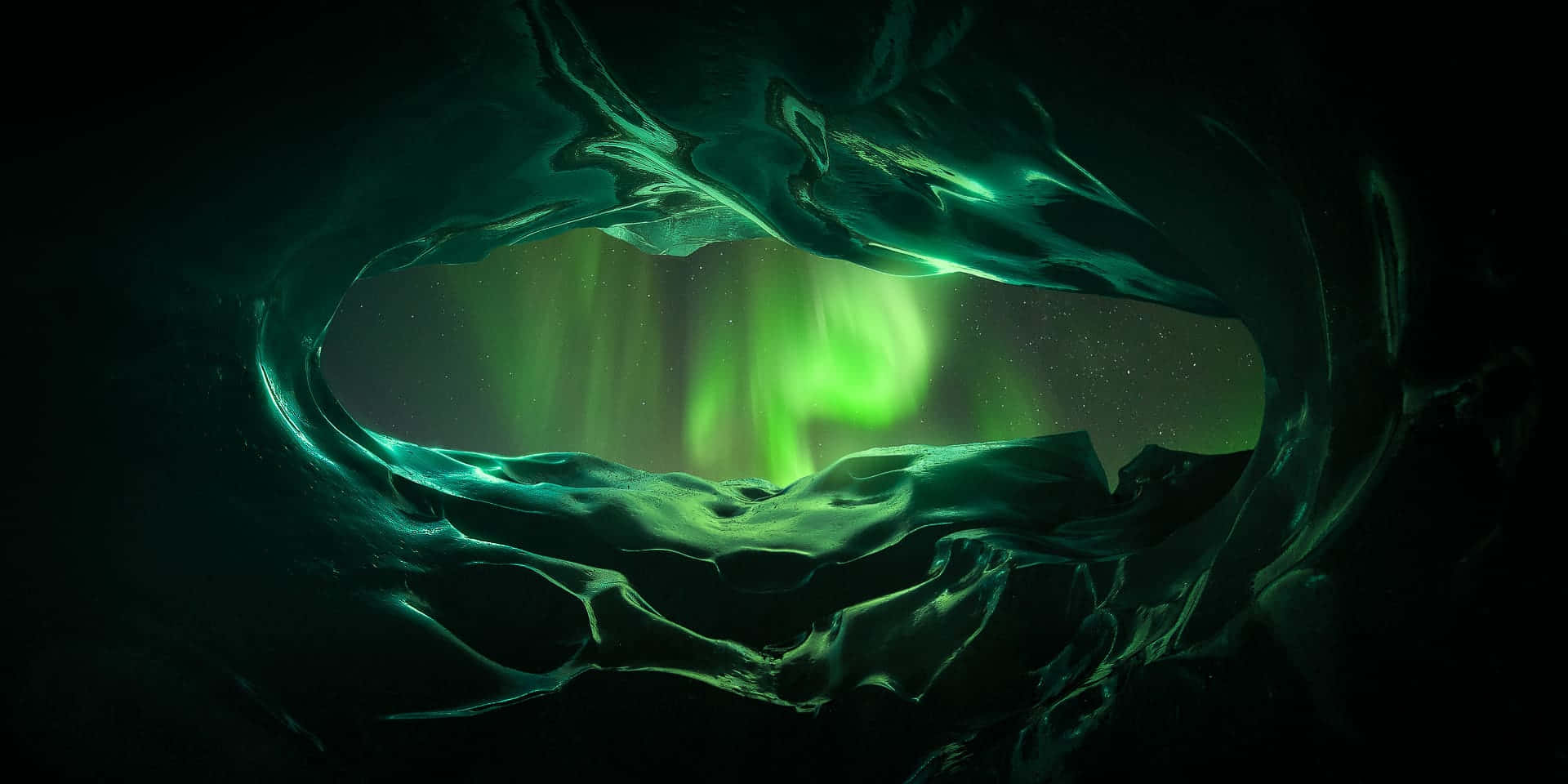 aurora borealis 桌布 壁紙 — 透過天然冰洞看到的發光綠色北極光，上方有星空。