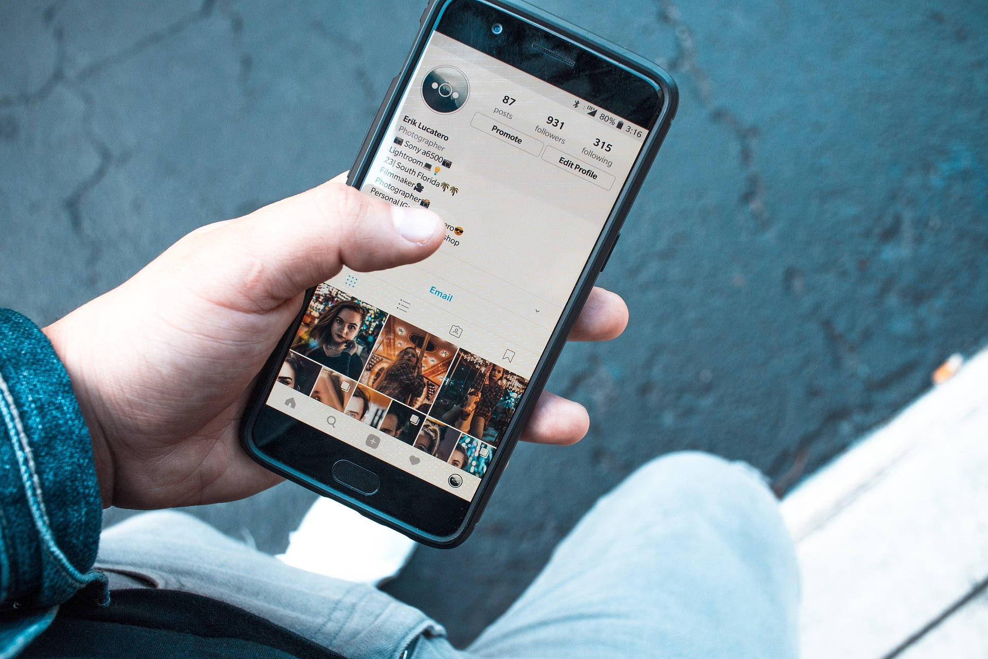 人拿著手機在路面上顯示Instagram個人資料