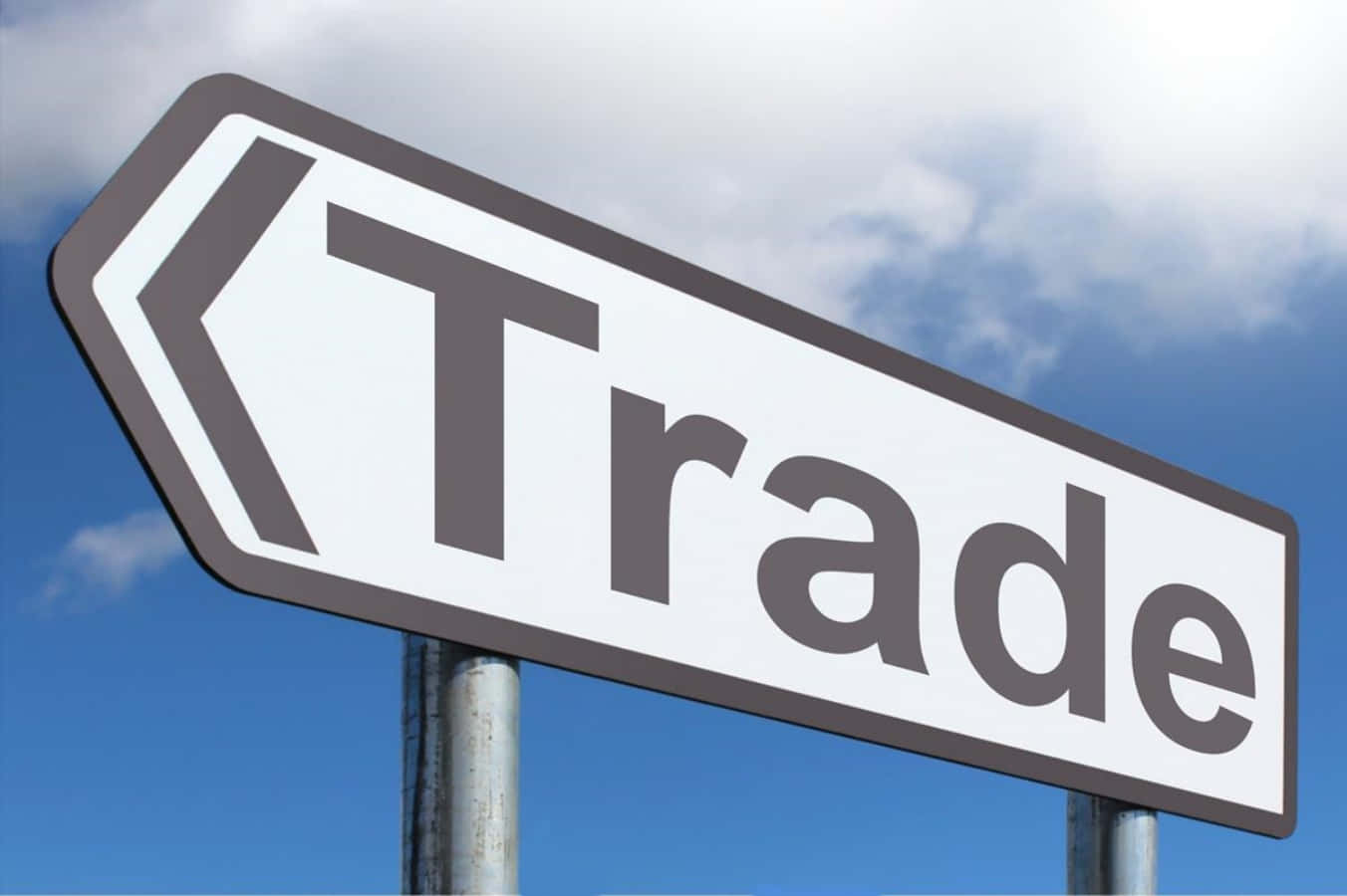 一個白色箭頭形路牌，上面寫著Trade，指向左邊，背景是藍天。