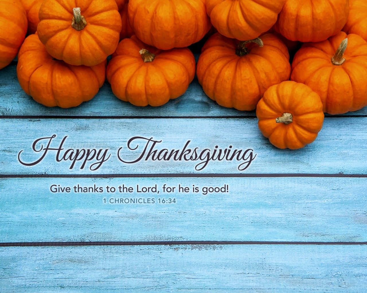 藍色木頭上的橙色南瓜，帶有「Happy Thanksgiving」和聖經經文文字。