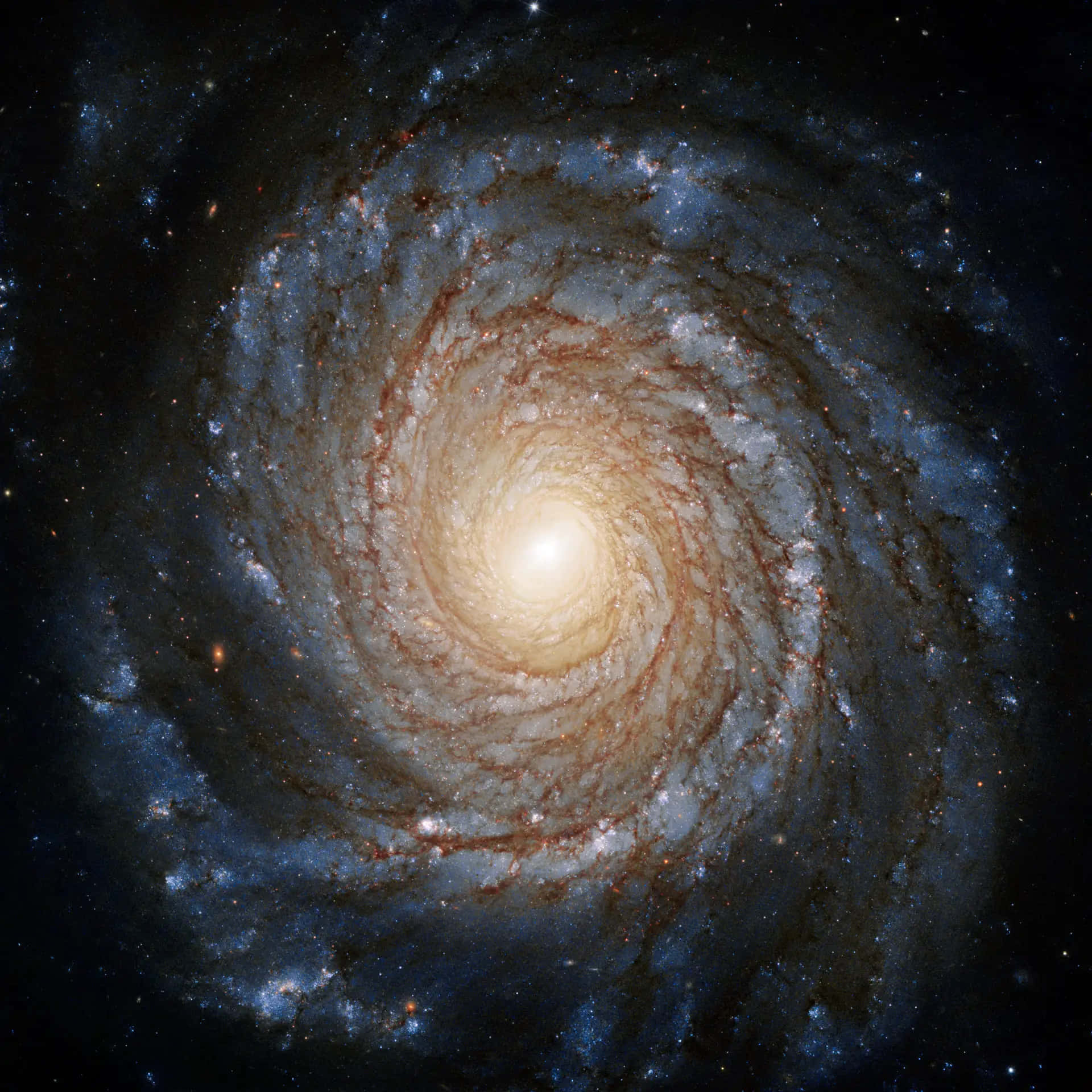 透過黑洞哈勃望遠鏡解開宇宙奧秘 壁紙 — 一個令人嘆為觀止的螺旋星系，帶有熾熱的橙色核心和充滿恆星與宇宙塵埃的旋轉藍色旋臂。
