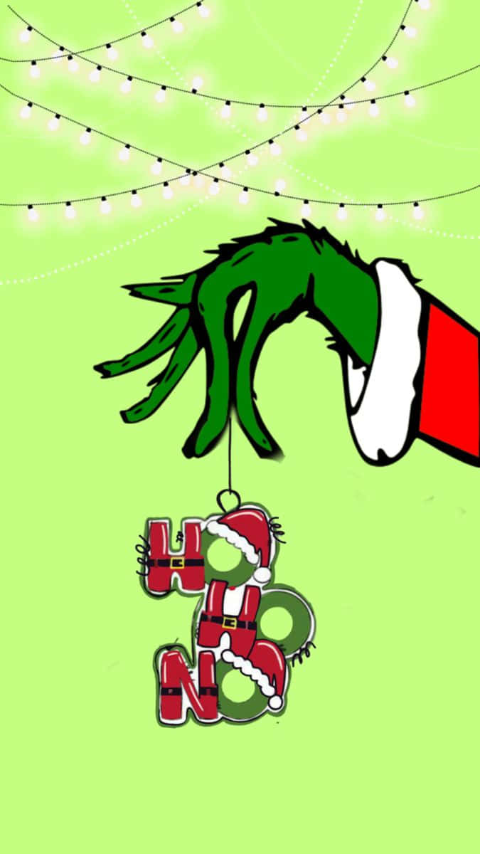 戴著聖誕帽的鬼靈精手，拿著一個上方有串燈的「HO HO HO」裝飾品。