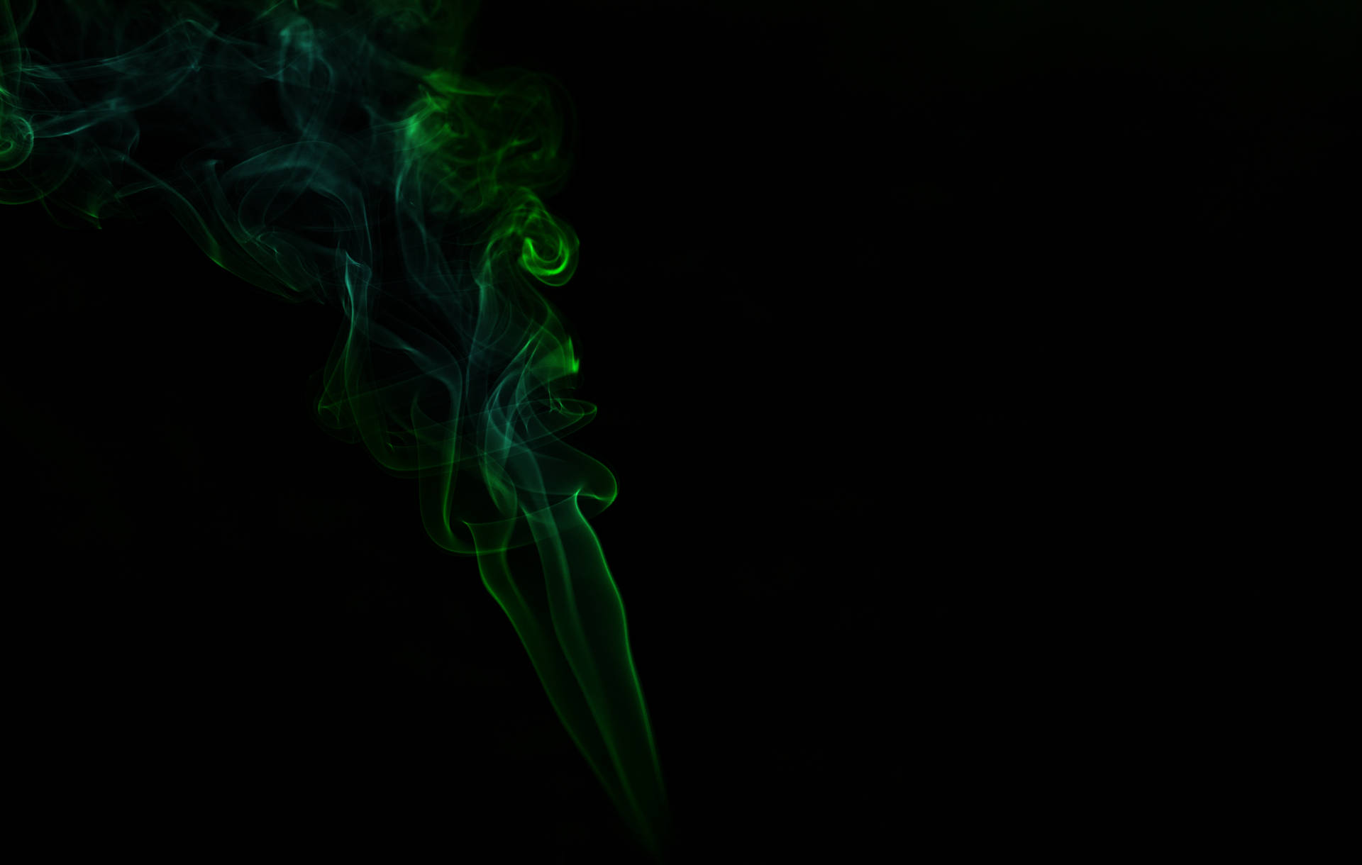 綠色煙霧在黑暗中飄移，形成平靜的抽象圖案。 — 深綠色 壁紙