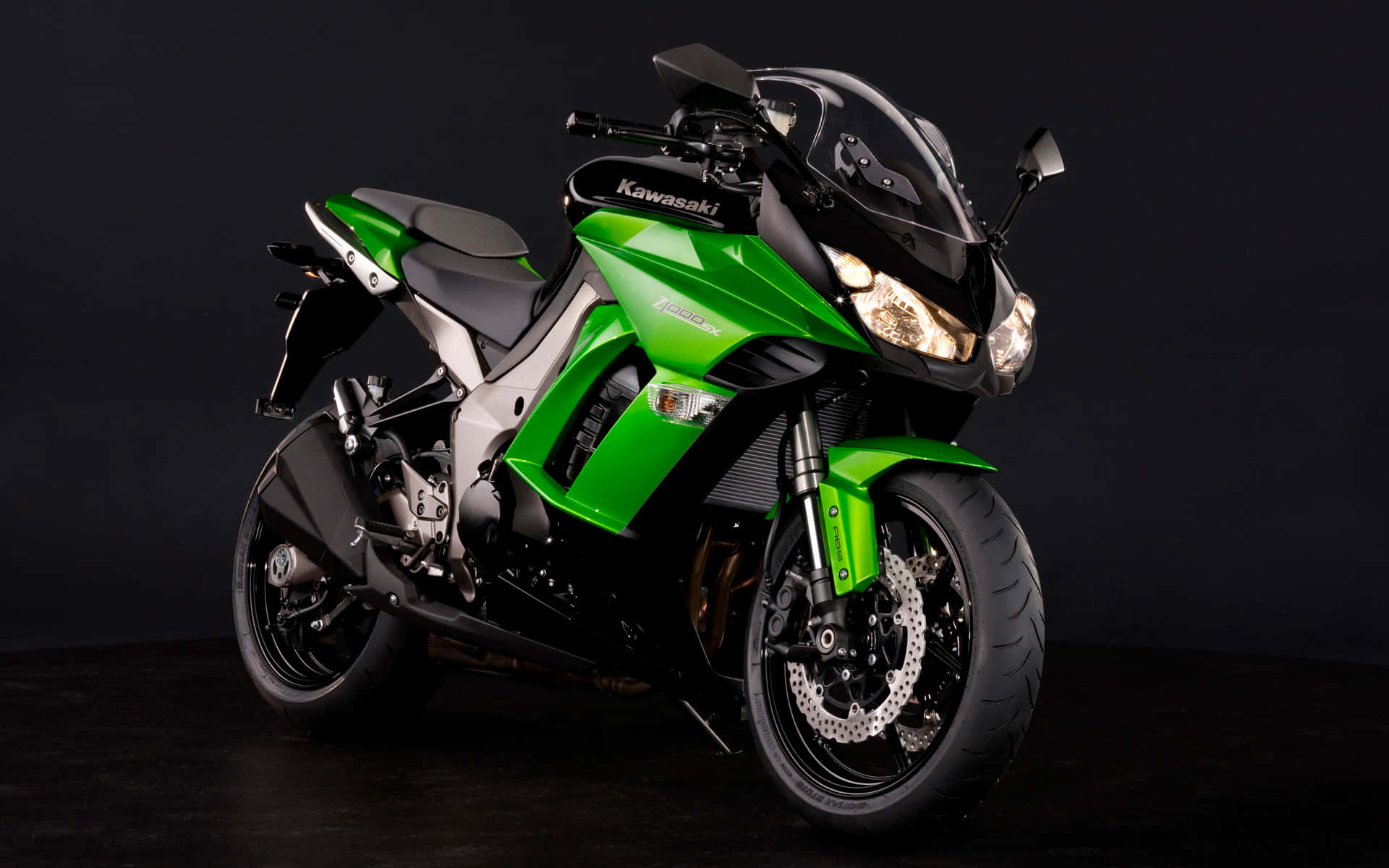 工作室燈光下的綠色和黑色 Kawasaki 運動摩托車。