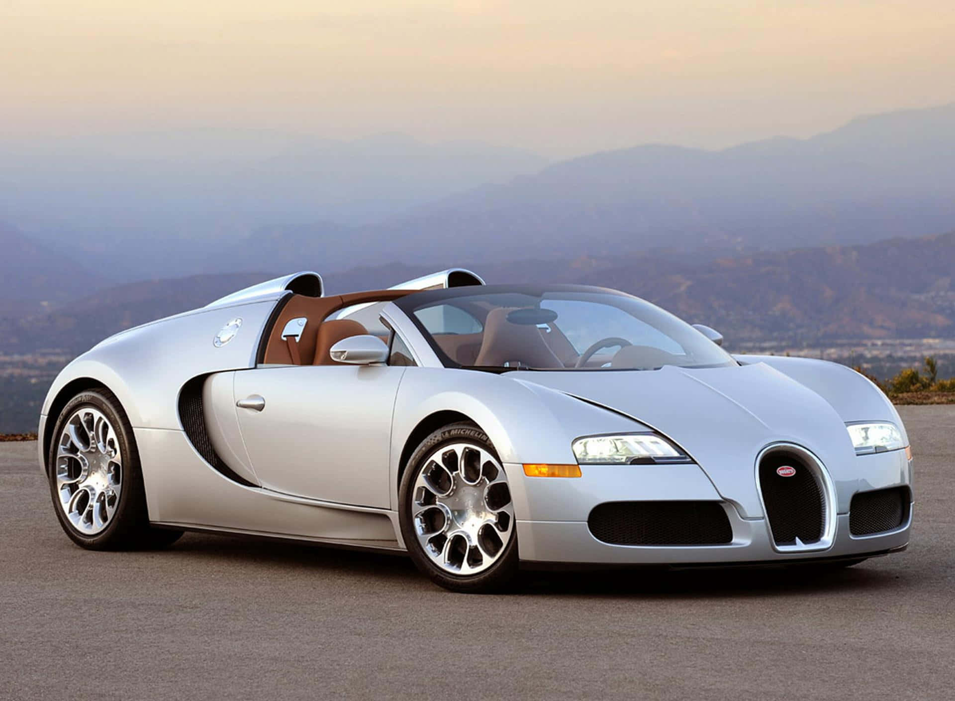 銀色 Bugatti Veyron 超級跑車在日落時分停在山路上。