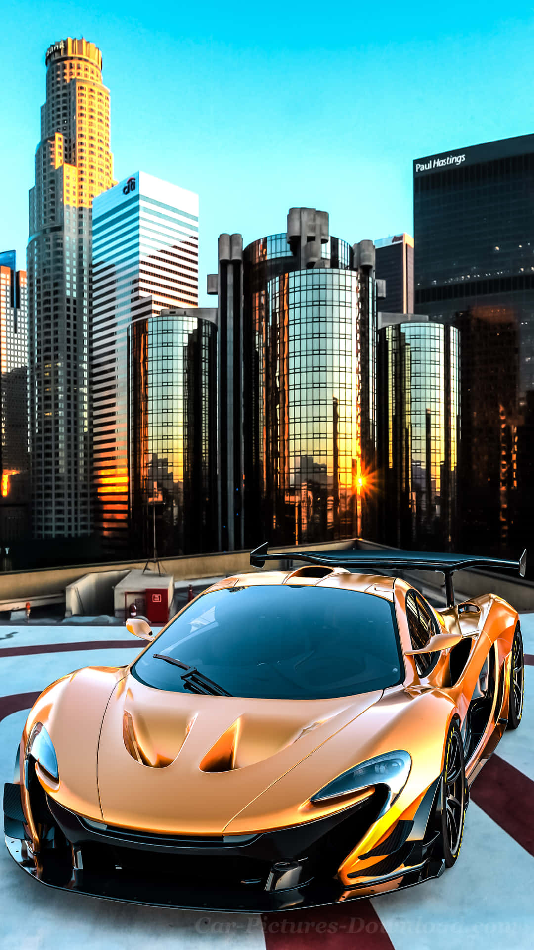 金色McLaren P1跑車在天台上，以城市天際線為背景，日落時分。
