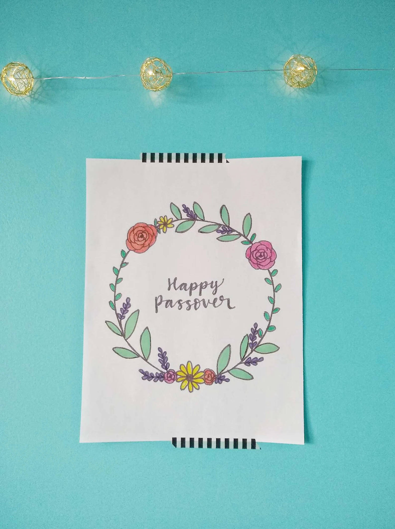逾越節快樂海報 壁紙 — 手繪花環，白色記事本上寫有「Happy Passover」字樣，背景為藍綠色牆壁及燈串。