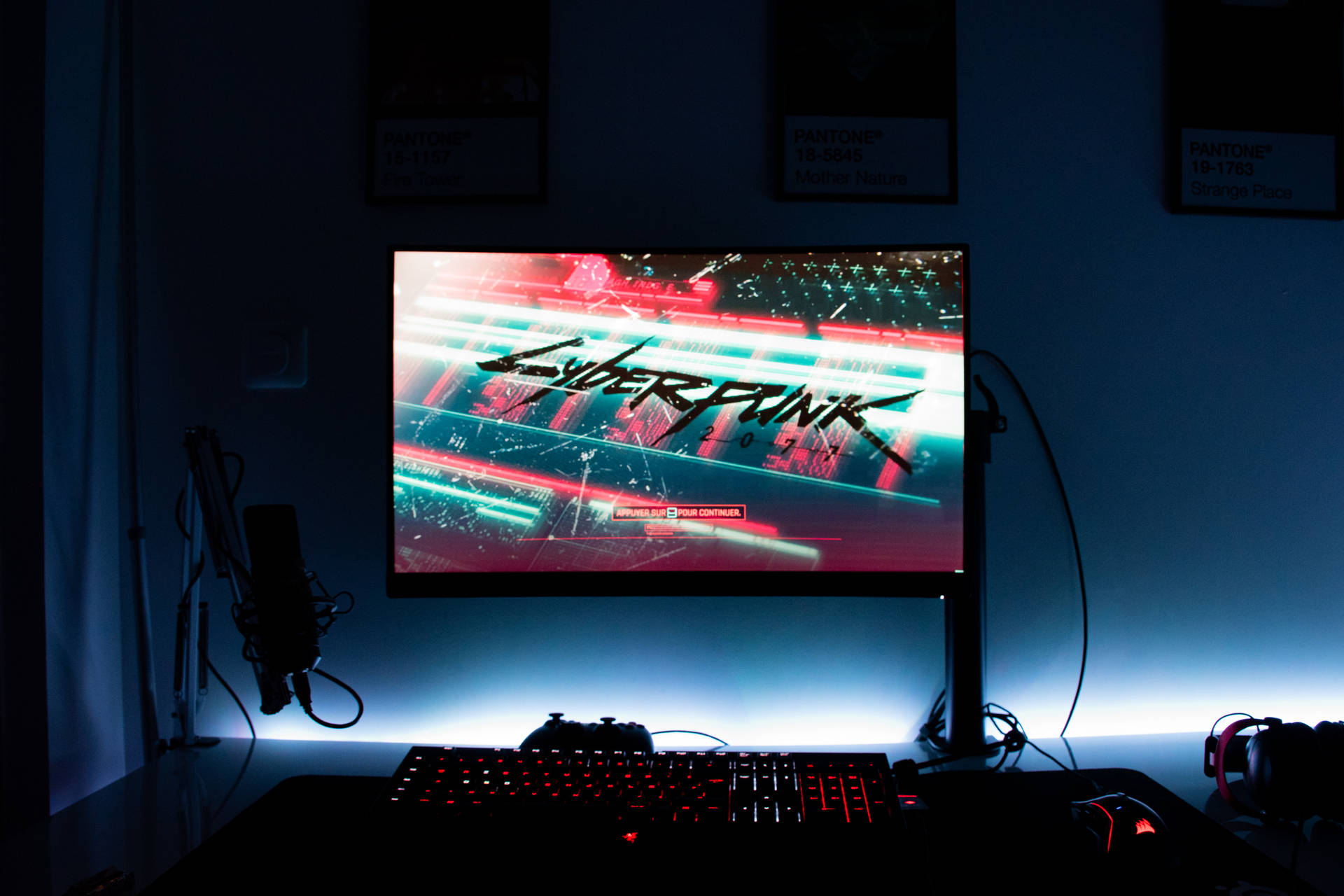 遊戲設置，屏幕上顯示Cyberpunk 2077，在黑暗的房間裡有發光的外設。