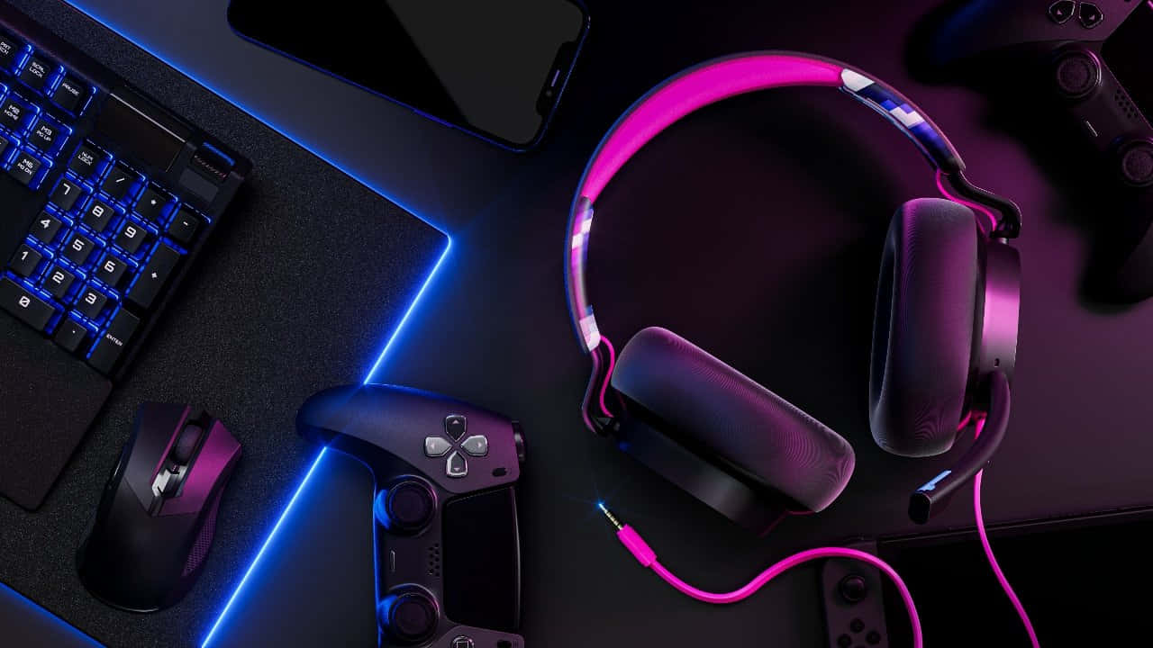 Gaming Headsets 桌布 壁紙 — 遊戲裝備包括耳機、控制器、滑鼠和鍵盤，在深色桌子上以鮮豔的粉紅色和藍色霓虹燈照亮。