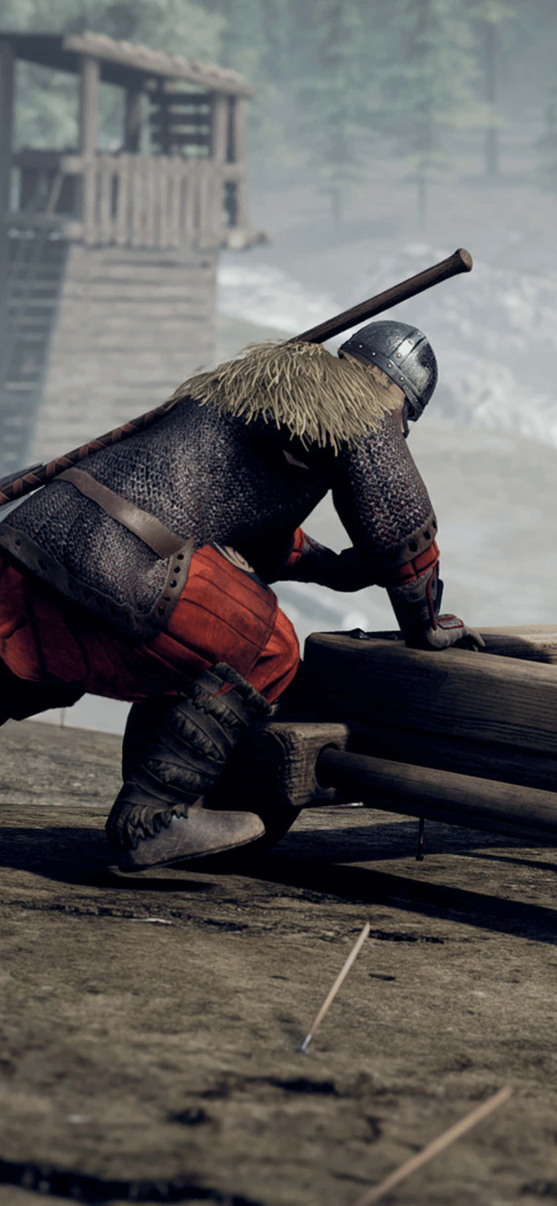 遊戲角色 iPhone XS Mordhau 背景 壁紙 — 一位身穿鎖子甲和頭盔的中世紀騎士跪在泥濘戰場上的木製攻城器械旁，背景中有一座木塔籠罩在迷霧中。