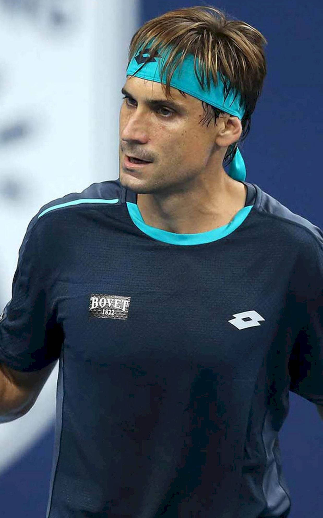 運動員的決心——職業網球選手戴維·費雷爾 壁紙 — 一位專注的男性網球運動員在比賽中戴著青綠色頭帶和深色運動衫。