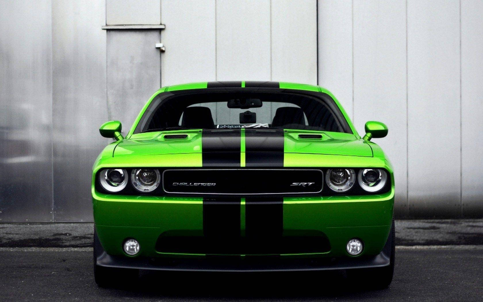 充滿活力的綠色Dodge Challenger SRT帶有黑色條紋，停放在灰色工業牆前。 — Dodge challenger GIF 壁紙