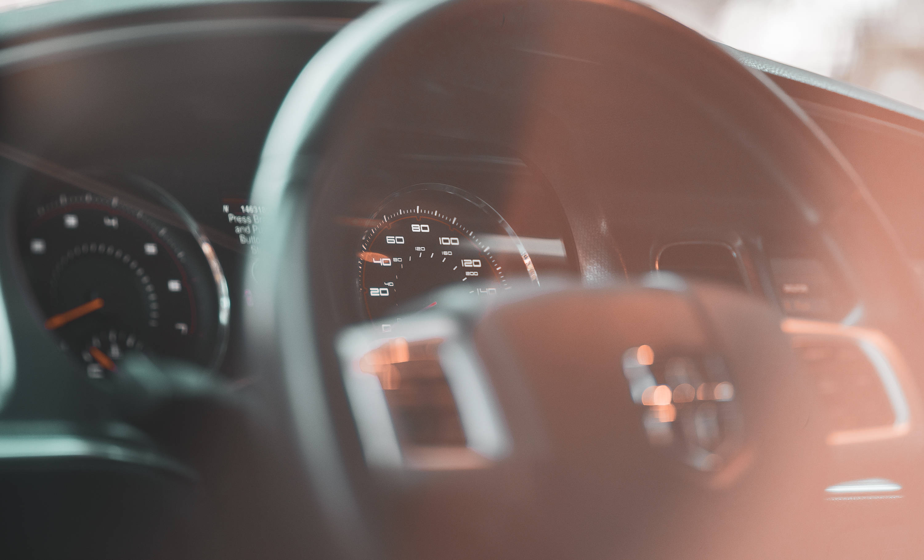 道奇挑戰者車內 壁紙 — 汽車方向盤和儀表板的特寫，溫暖的陽光透過擋風玻璃照射進來。