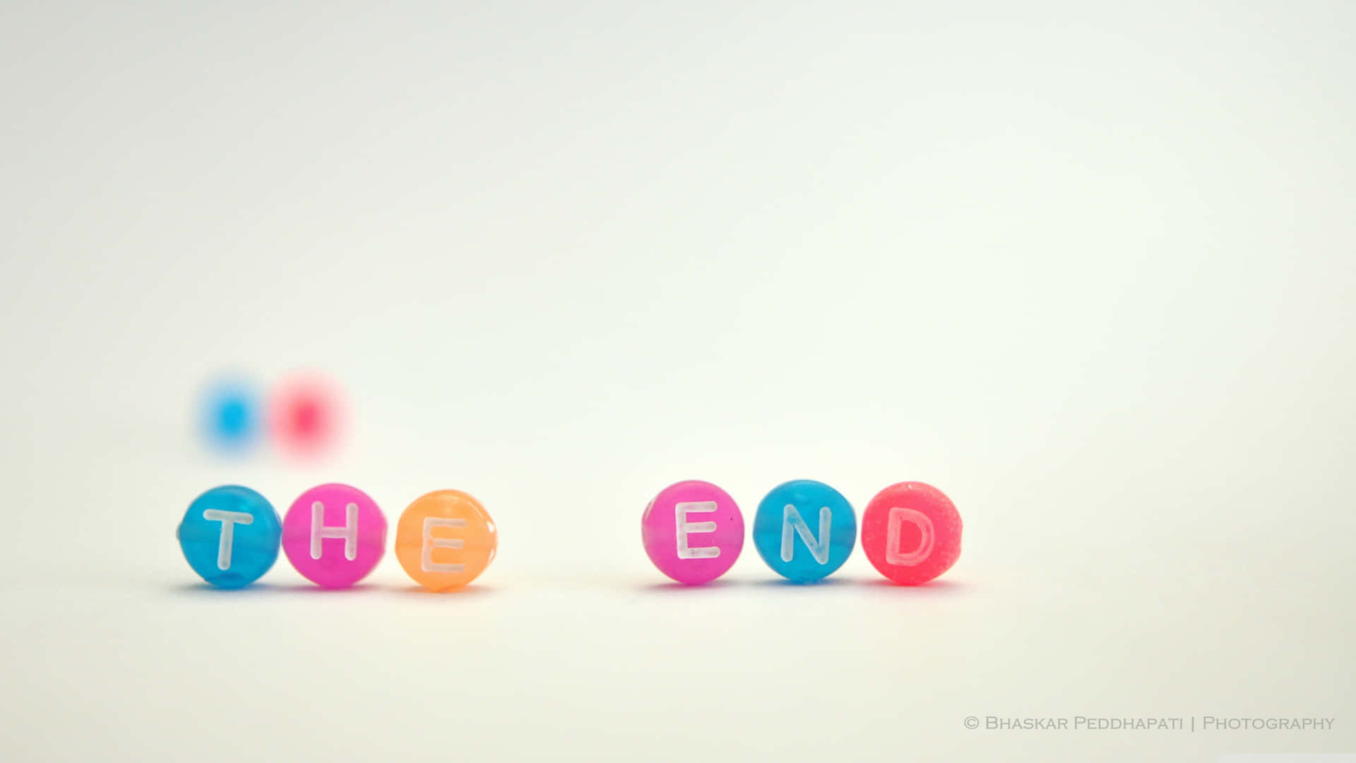 白色背景上拼出 the end 的彩色珠子