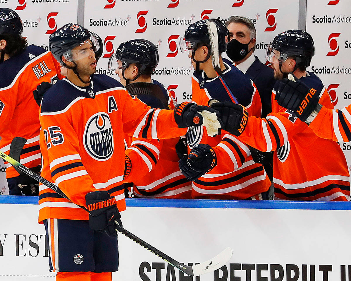 達內爾·納斯在埃德蒙頓油人隊對陣 Anaheim Ducks 2018 壁紙 — 身穿橙色愛民頓油人隊球衣的曲棍球球員與隊友和教練在場邊慶祝。
