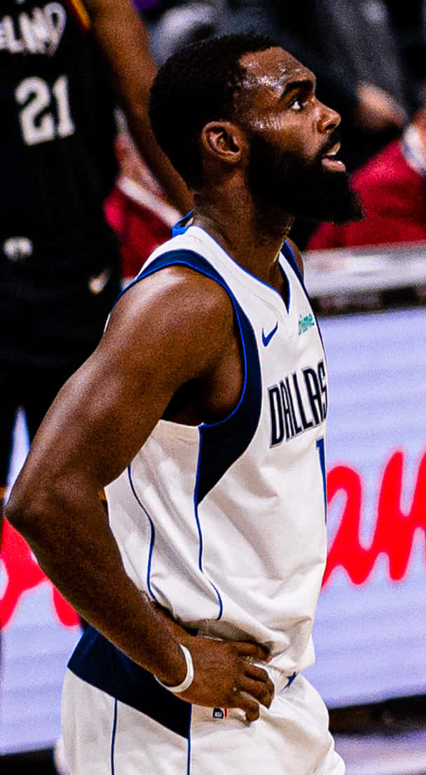 身穿達拉斯獨行俠球衣的籃球運動員雙手叉腰站在球場上。