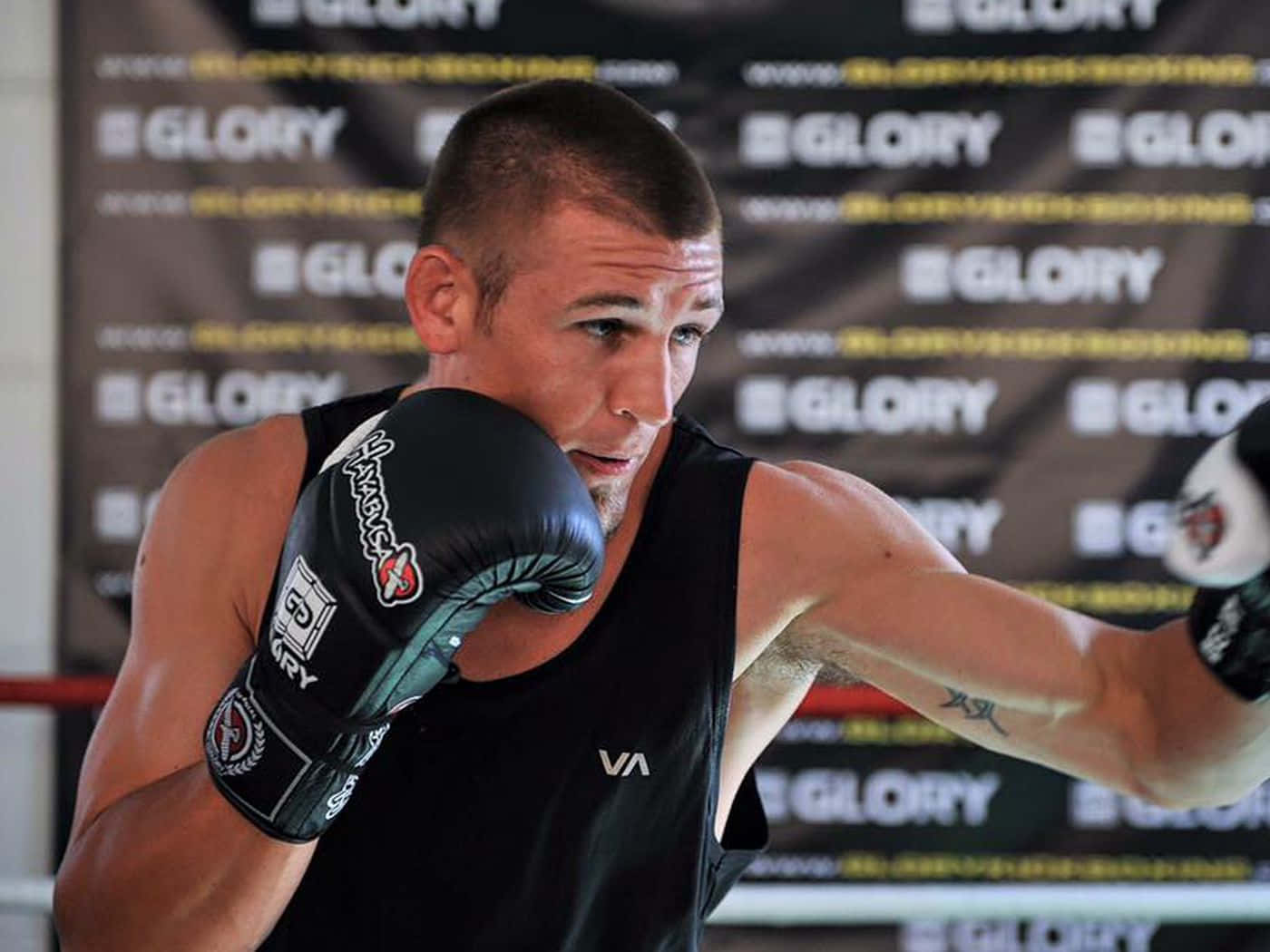 運動員戴著拳擊手套在GLORY品牌擂台內出拳。