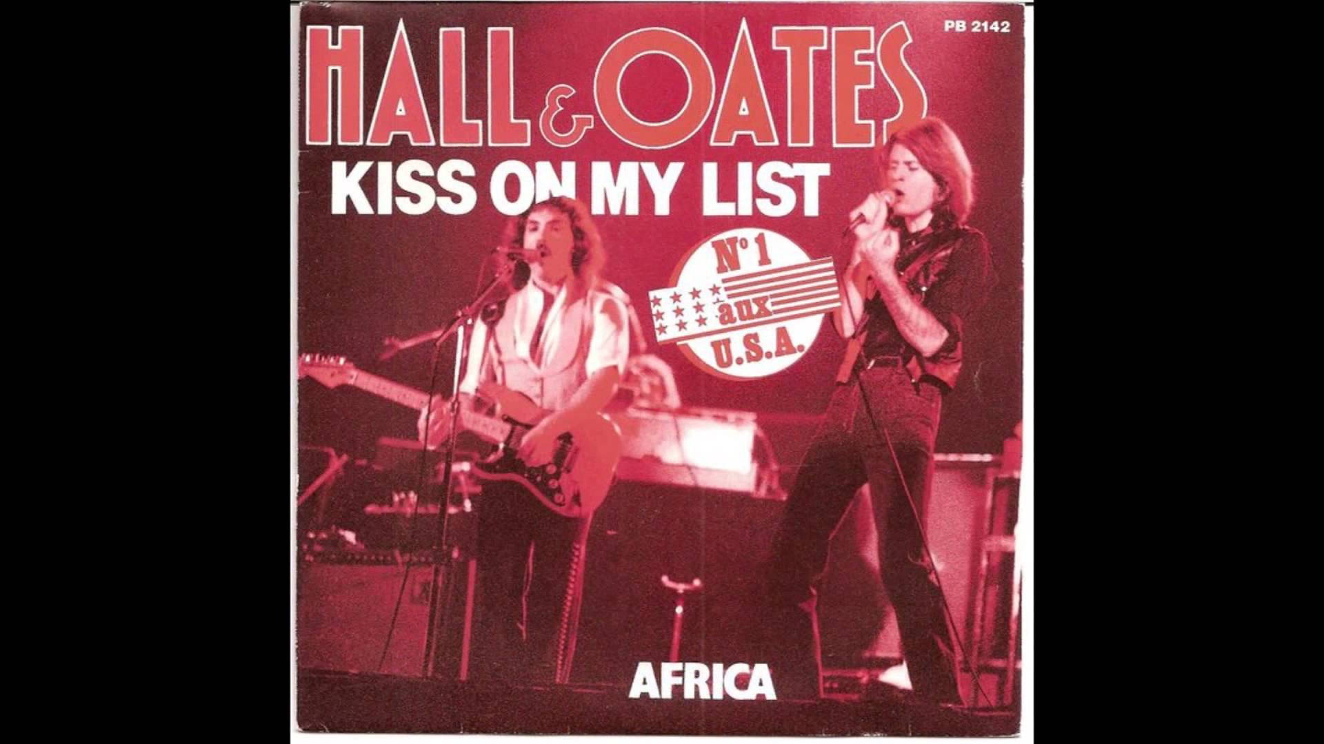 Hall & Oates 在舞台上現場表演，紅色燈光，專輯標題可見。