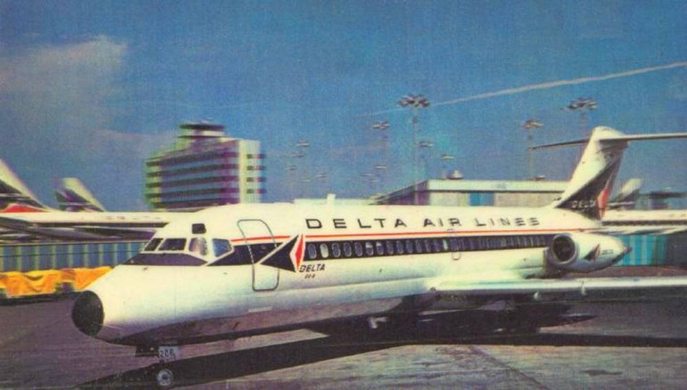 達美航空飛機停泊在機場停機坪，背景有建築物