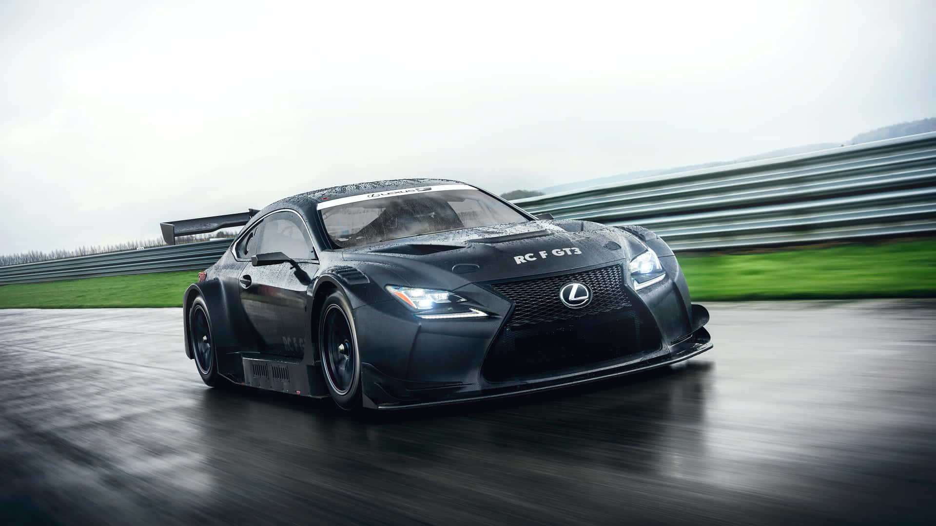 黑色 Lexus RC F GT3 賽車在潮濕賽道上疾馳，帶有動態模糊效果。