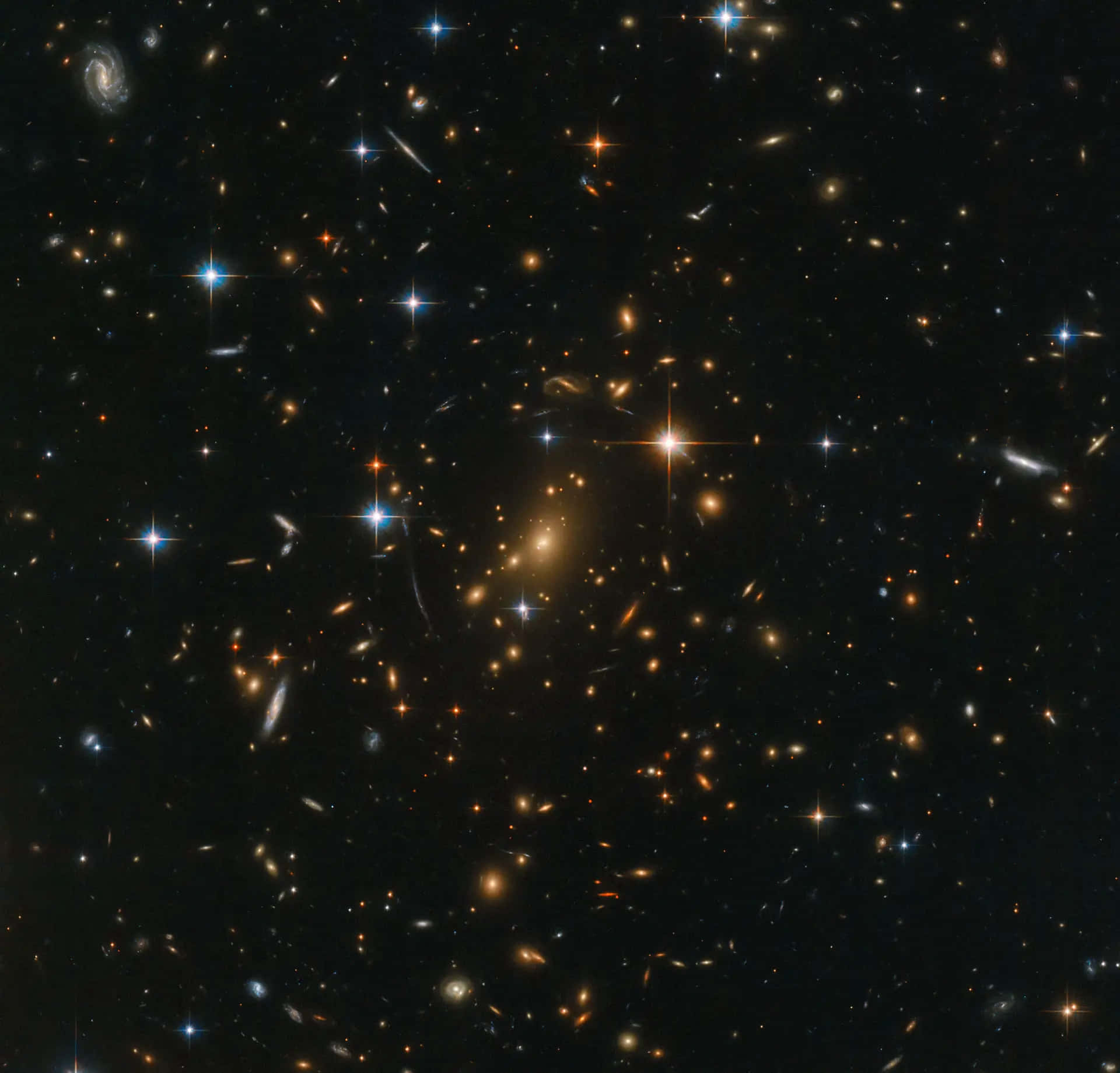 深空中密集的恆星和星系場，帶有明亮的星爆和螺旋結構。