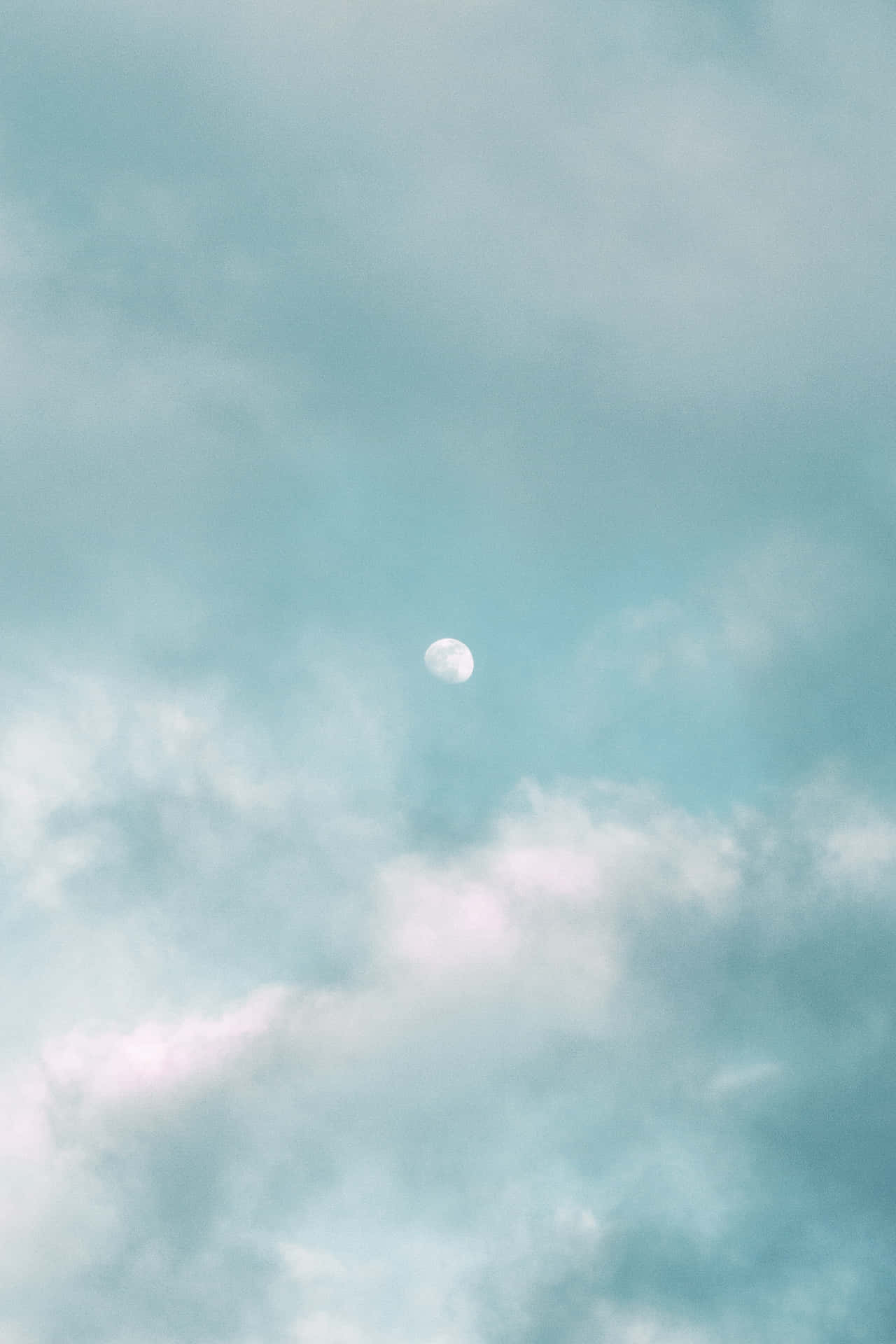 蒼白的月亮在寧靜的藍色天空中飄過柔軟的雲朵。