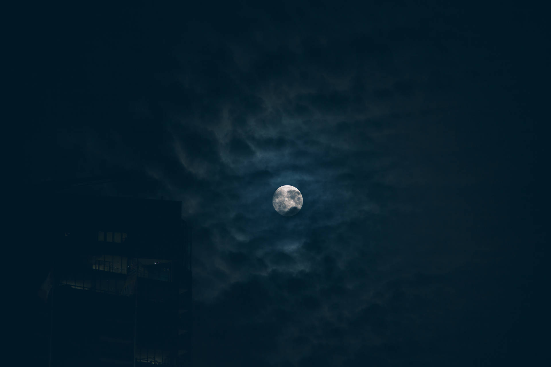 滿月穿過烏雲在城市上空閃耀。