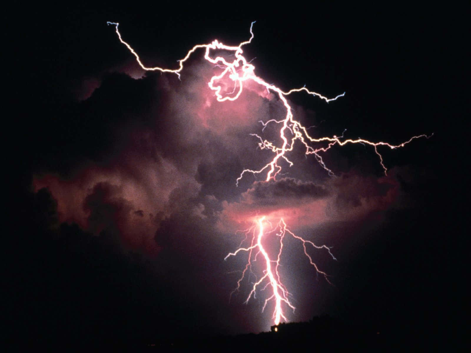 強烈的閃電在夜間照亮了黑暗的暴風雲。