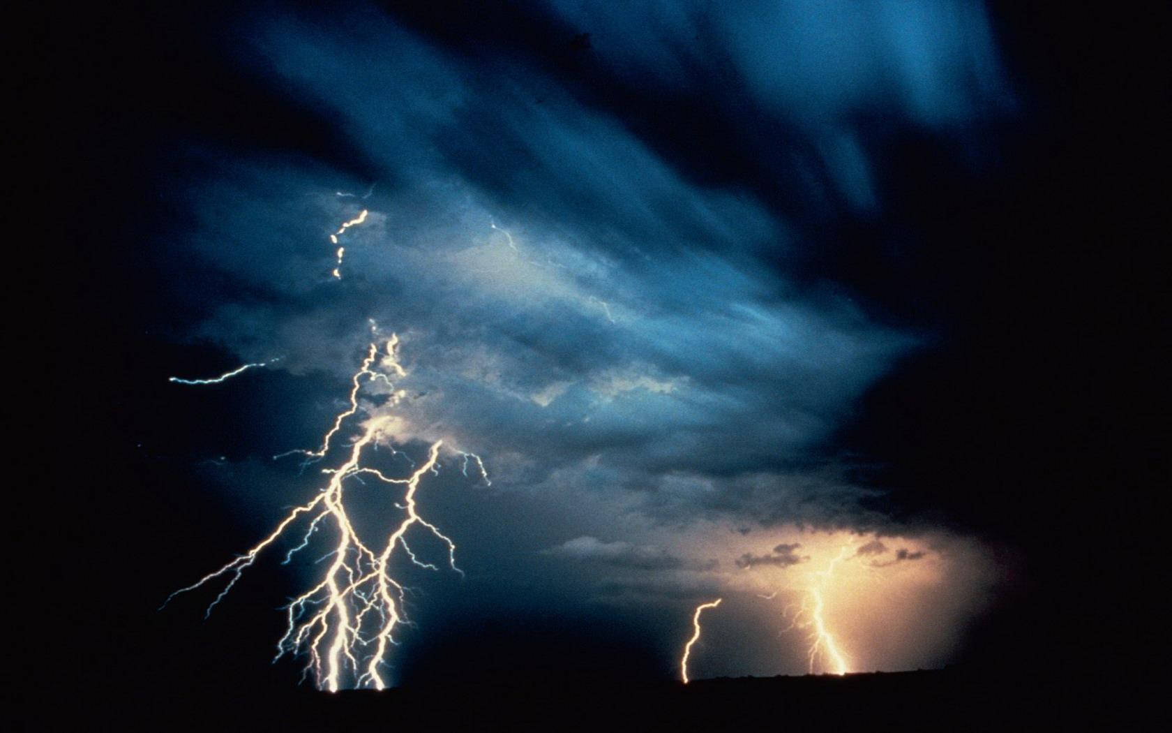 強大的閃電照亮了帶有烏雲的暴風雨夜空。