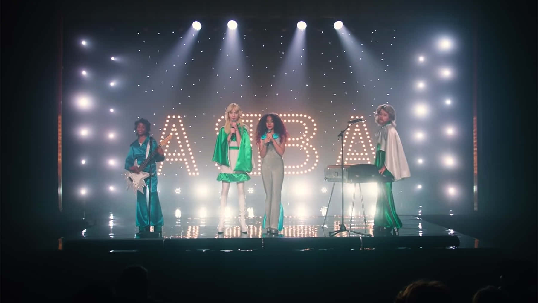 ABBA 樂隊在發光字母和聚光燈的舞台上表演。
