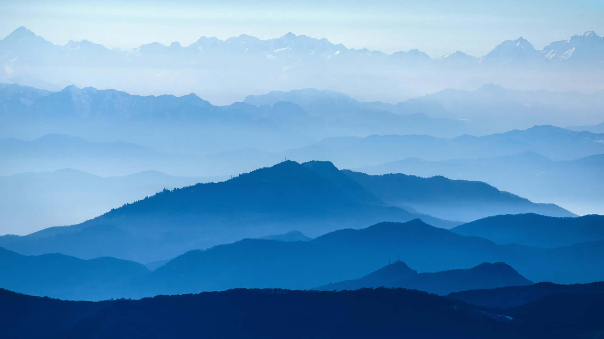 寧靜的山景，層疊的山峰消失在藍色薄霧中。