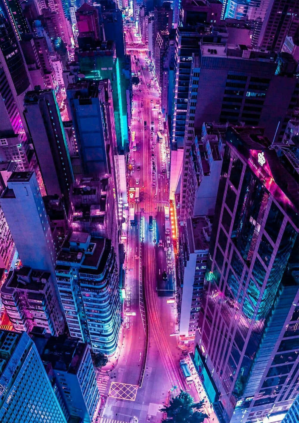 夜晚發光的霓虹城市街道鳥瞰圖，周圍環繞著高樓大廈。