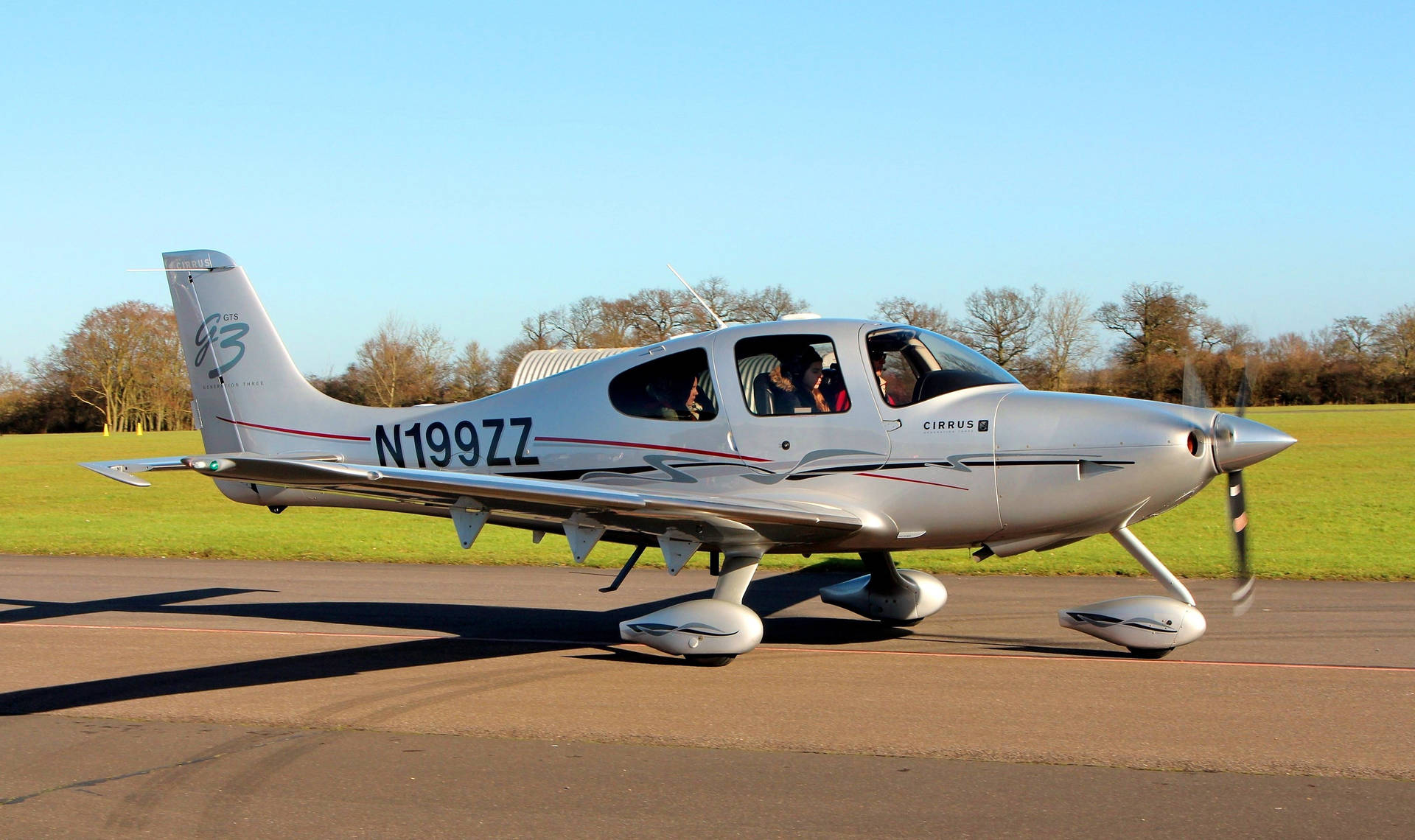 跑道上的銀色 Cirrus SR22 飛機，機艙內可見乘客。