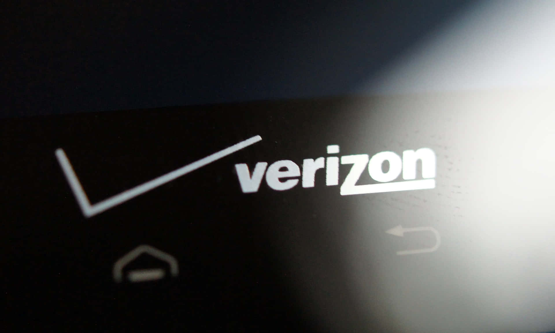 Verizon標誌在智能手機屏幕上，帶有模糊的導航圖標。