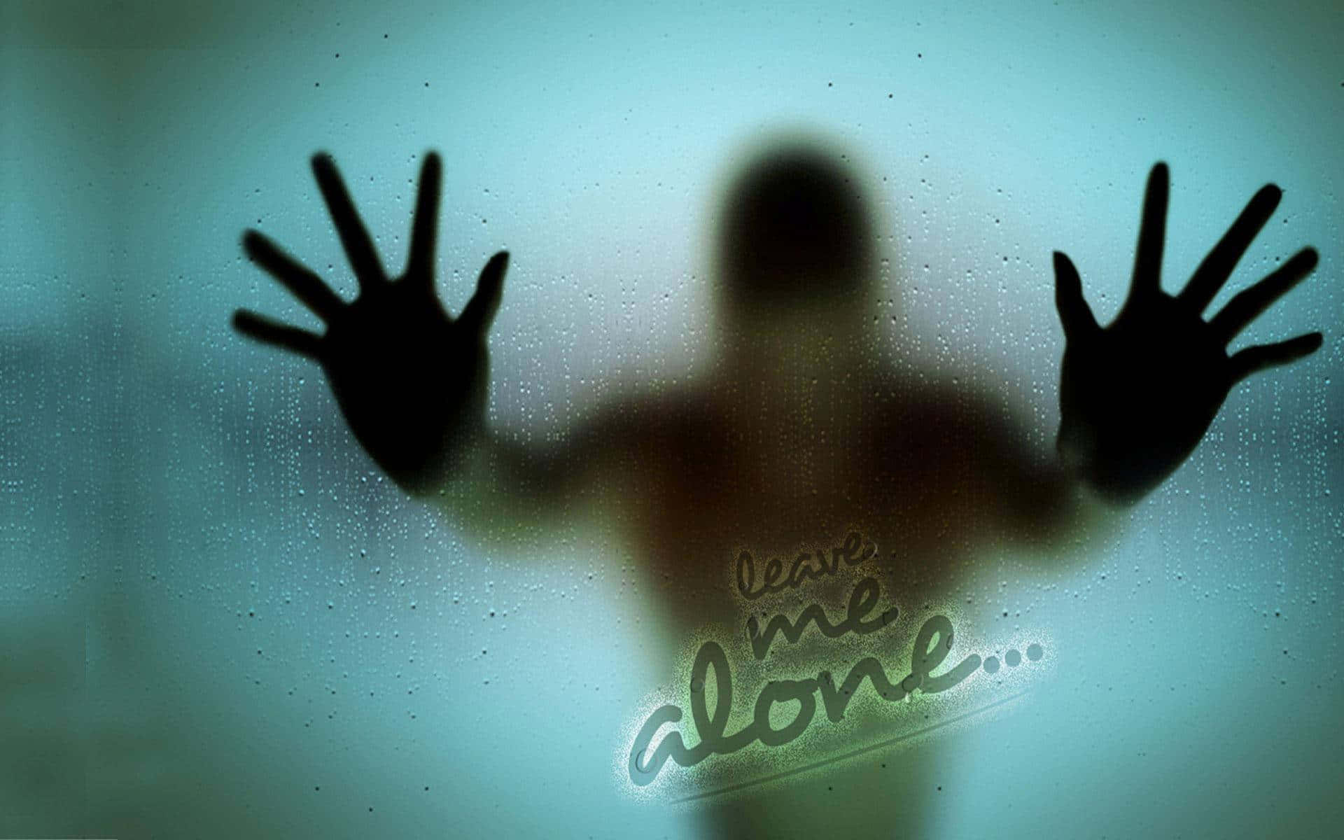 一個陰暗嘅人影將手按喺濕窗上，有發光嘅文字寫住「leave me alone」。