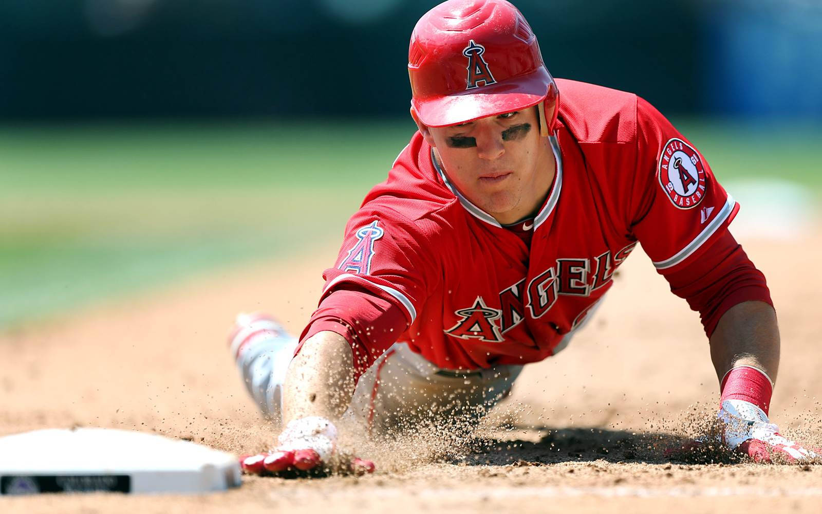 邁克·特勞特衝向本壘 壁紙 — 身穿紅色天使隊球衣的棒球選手在日間比賽中頭部滑壘進壘，揚起泥土。