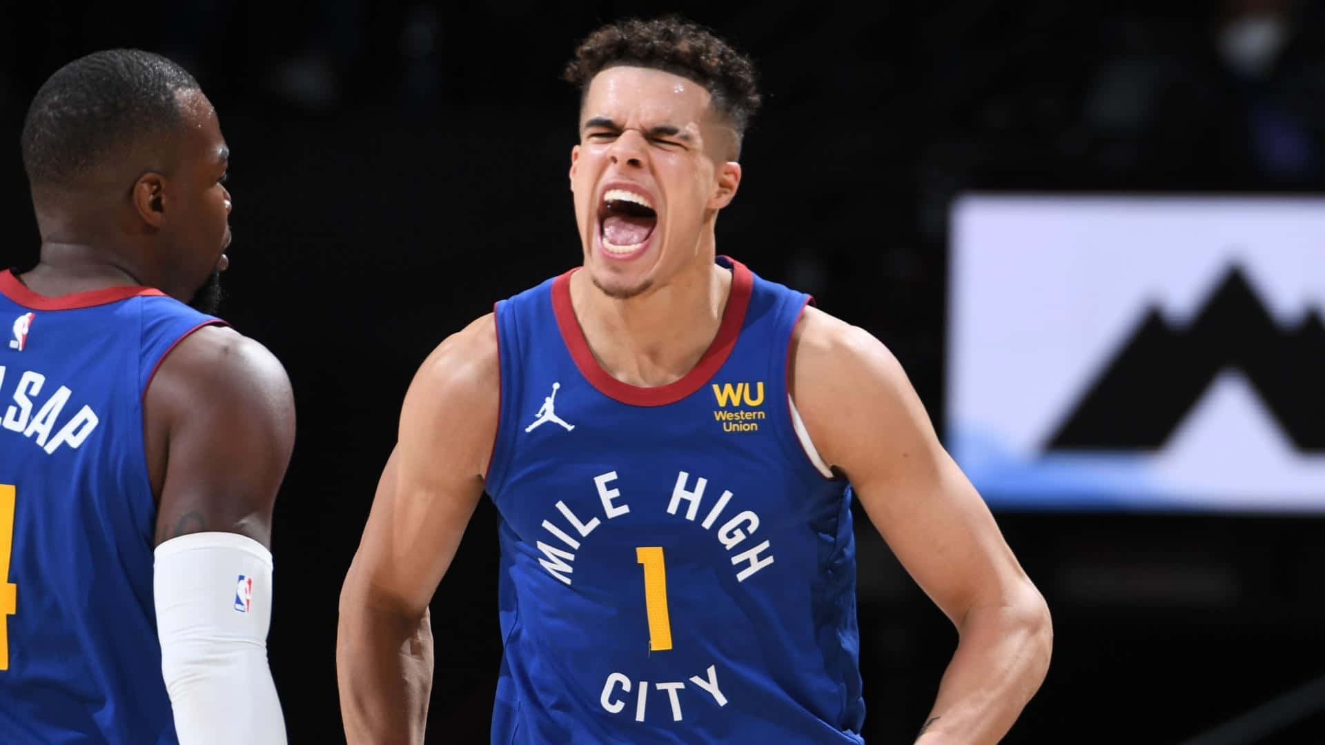 邁克爾·波特 Jr. 高聲慶祝 壁紙 — 一名身穿藍色「Mile High City」球衣的籃球運動員在比賽中熱情地吶喊，隊友在旁觀看。