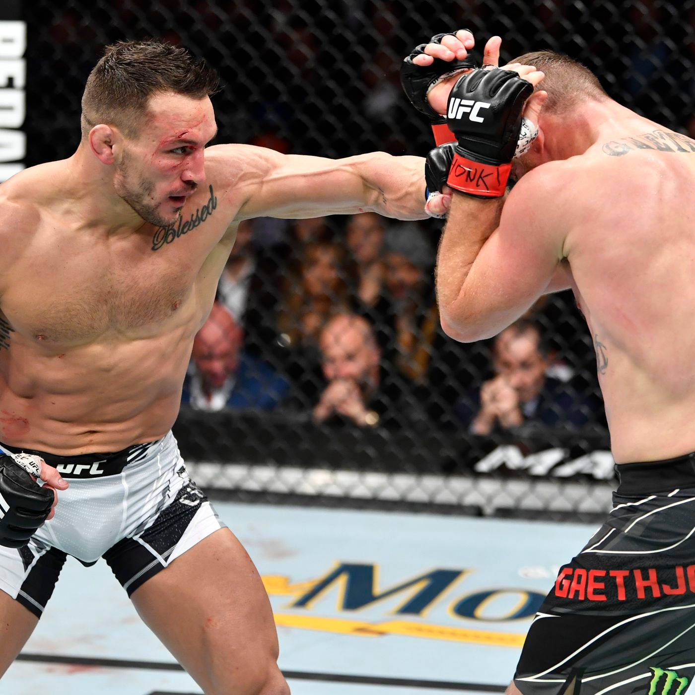 兩名男性MMA拳手在八角籠中，其中一人出拳。
