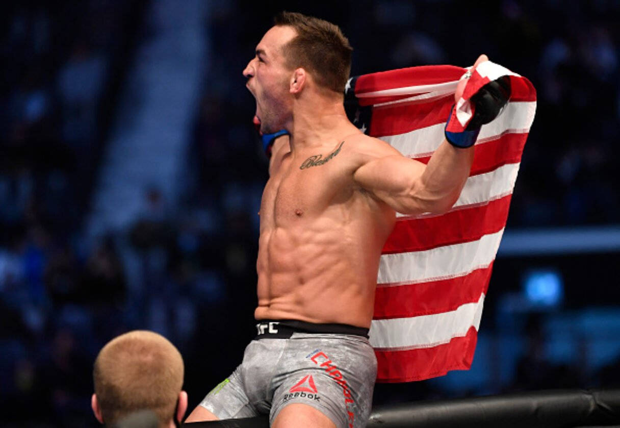 MMA拳手在擂台上高舉美國國旗慶祝勝利。