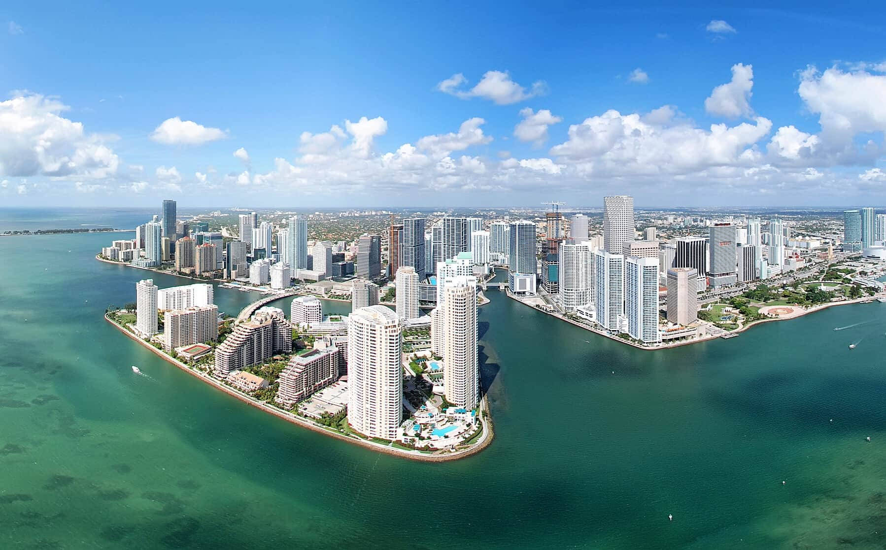 邁阿密城市空中俯瞰 壁紙 — 現代沿海城市景觀的鳥瞰圖，高樓大廈林立，碧綠的海水，明亮的藍天白雲。