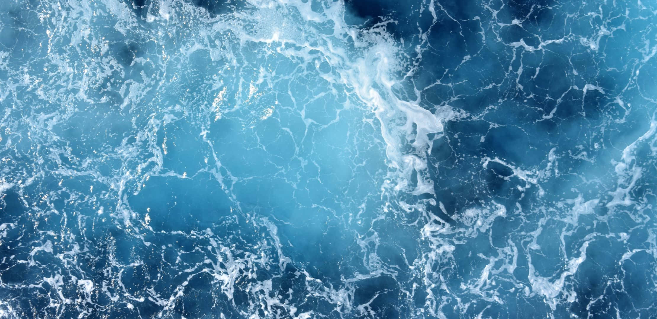 波濤洶湧的海浪在深藍色海水中翻騰，泛起白色泡沫。