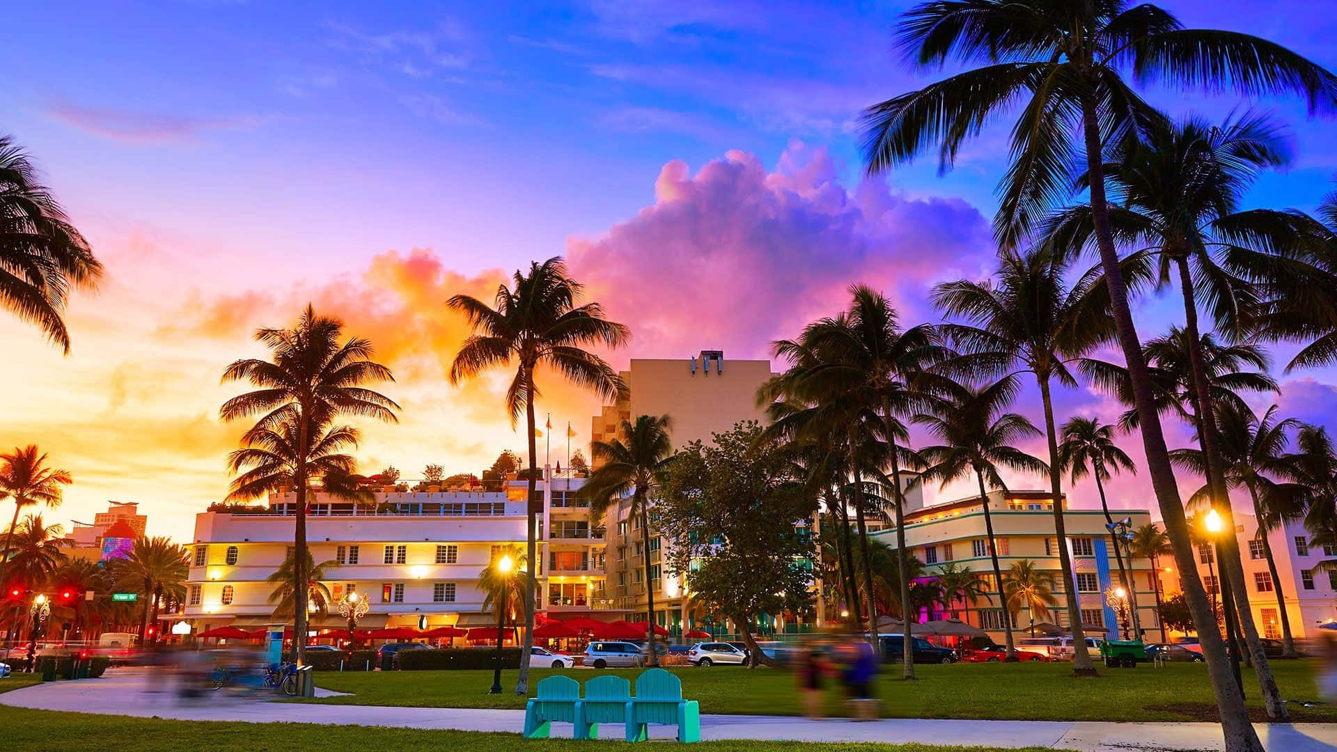 Miami 桌布 壁紙 — 邁阿密海灘上充滿活力的日落，棕櫚樹在粉紅色、紫色和橙色的天空下形成剪影。