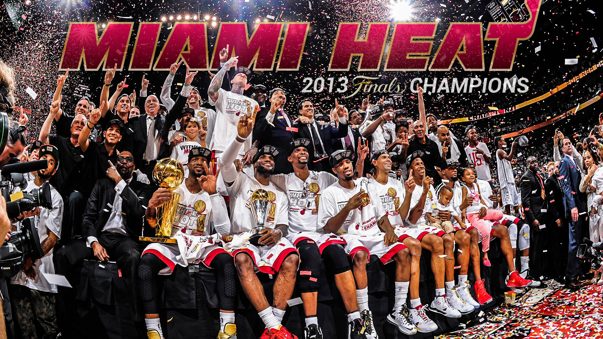 邁阿密熱火 2013 NBA 总决赛 壁紙 — 邁阿密熱火籃球隊在場館內以獎盃、五彩紙屑和狂喜的球員慶祝2013年NBA總決賽勝利。