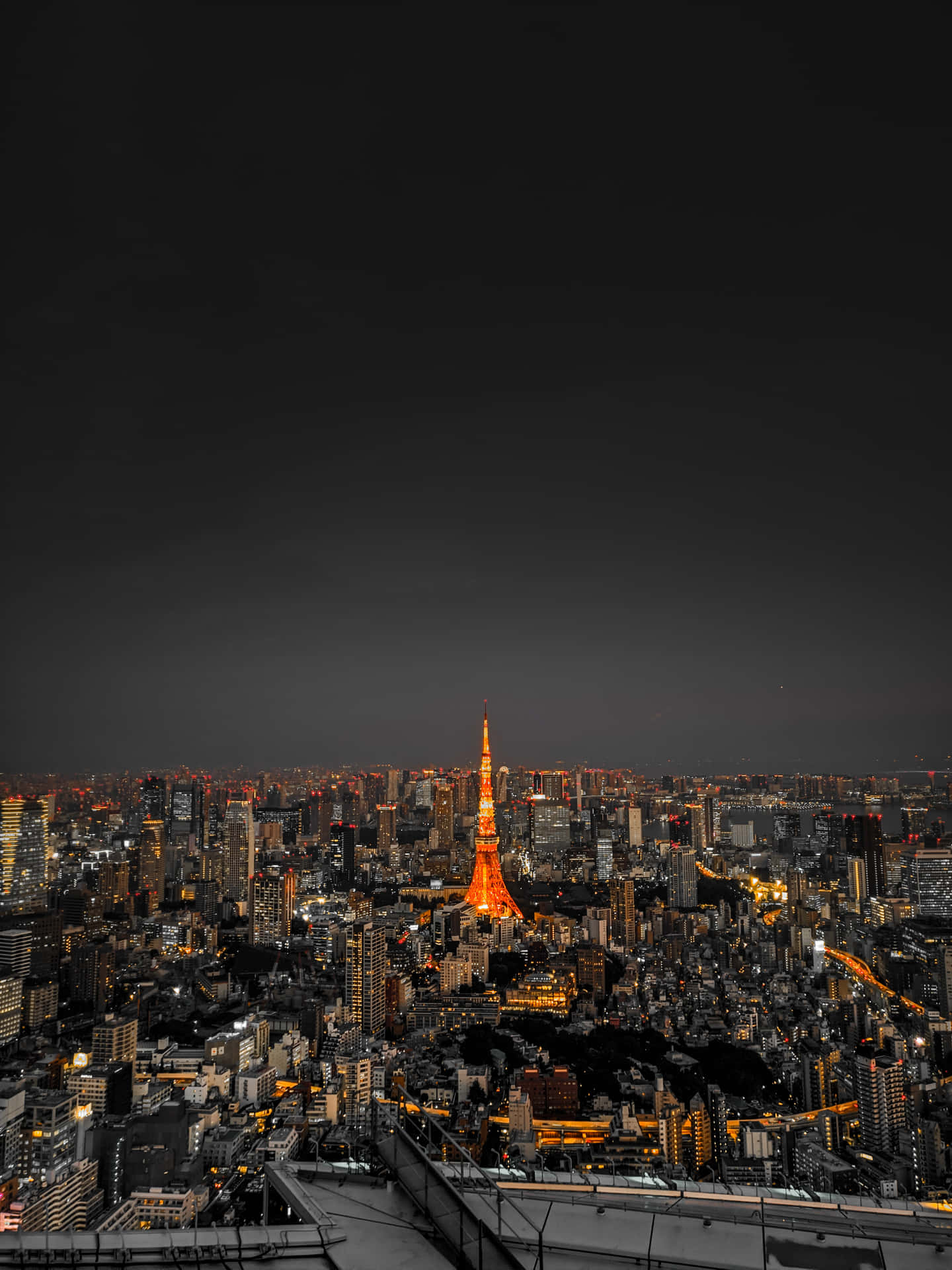 東京鐵塔在夜間照亮密集的城市景觀。